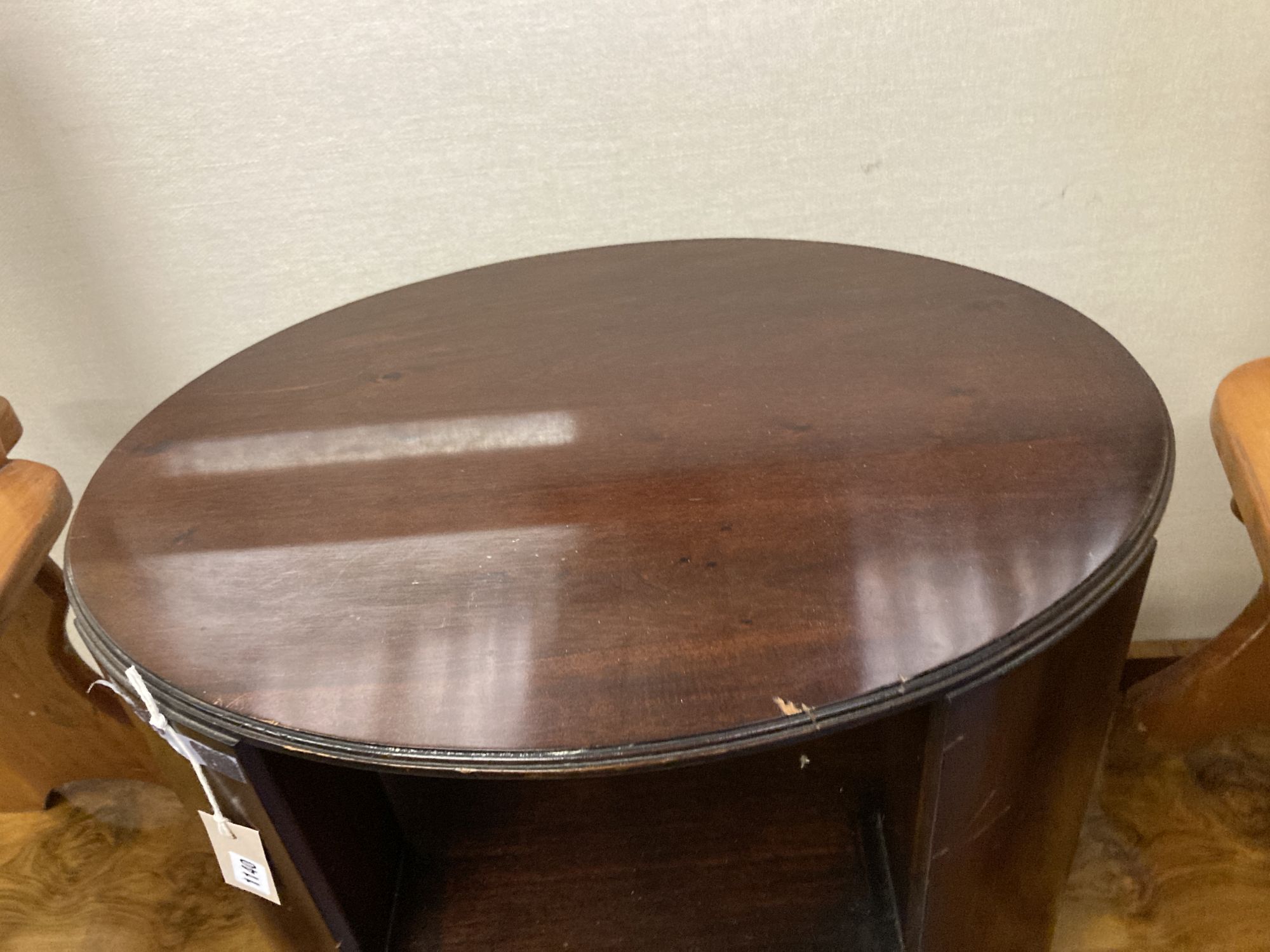 An oval mahogany three tier occasional table, width 64cm depth 50cm height 55cm